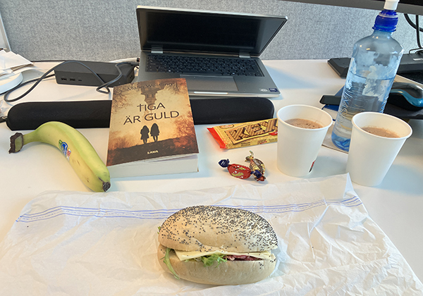 Skrivbordslunch macka kexchoklad banan kolor varm choklad o boken Tiga är guld