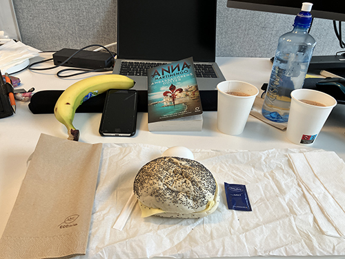 Skrivbordslunch med macka ägg banan och boken Ambassadörens dotter