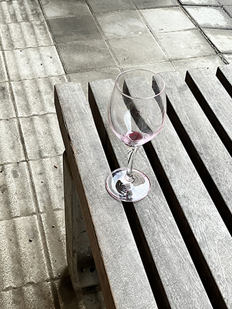 Tomt rödvinsglas på en bänk
