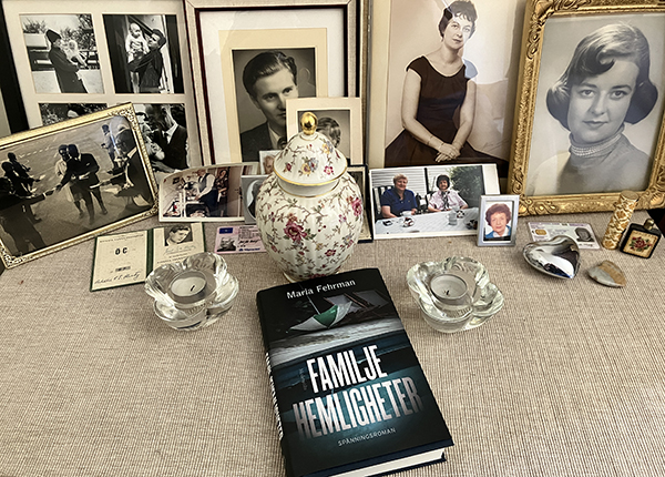 Boken Familjehemligheter på kistan med foton av mina föräldrar