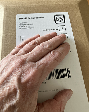 Brunt bokpaket med min hand på