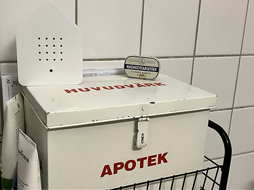 Fågelkvitterbox och magnecylburk ovanpå medicinlådan i badrummet
