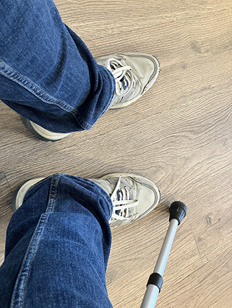 Jeansben o fötter m en krycka i väntrummet