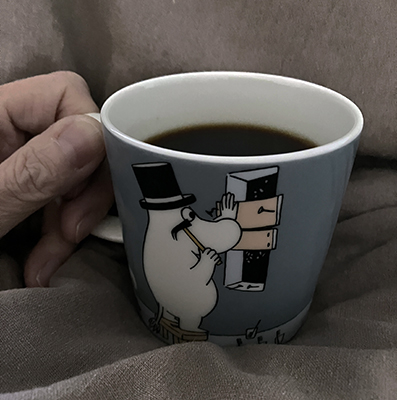 Kaffe på sängen i Muminpappan mugg där han spikar för fönster