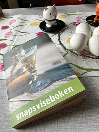 Lilla snapsviseboken intill äggen