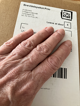 Min hand på brunt paket