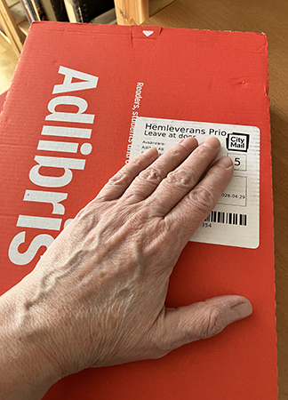 Paket från Adlibris med min hand på