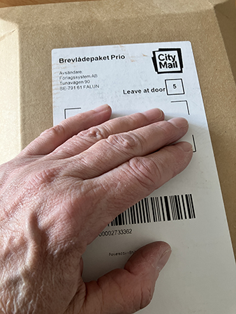 Brunt paket med min hand på
