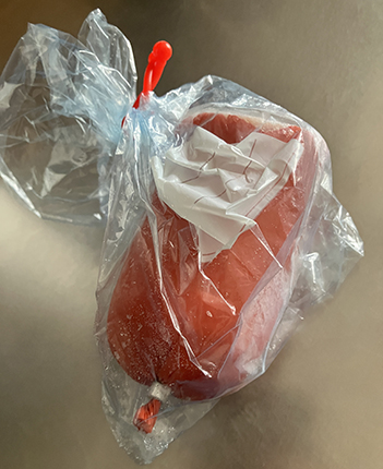 En bit kycklingstekkorv i plastpåse på tining En bit kycklingstekkorv i plastpåse på tining