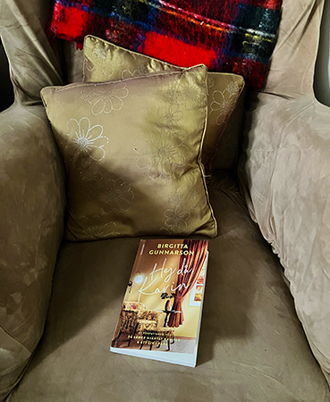 Farfarsfåtöljen med boken Hej då Karin