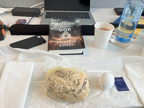 Skrivbordslunch på jobbet med boken Där rosor aldrig dör