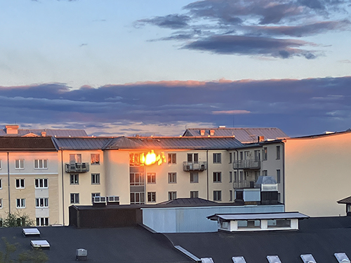 Solnedgång speglas i ett fönster
