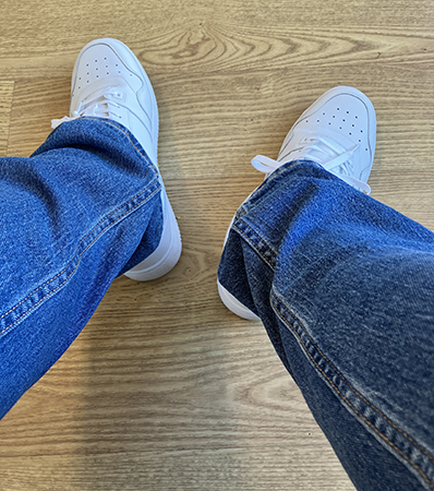 Vita Tommy Hilfigerskor och mina jeansben i väntrummet