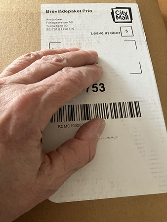 Brunt paket med min hand på