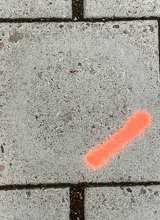 Orange streck på trottoarplatta