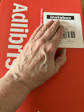 Paket från Adlibris med min hand på