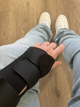 I väntrummet med hand i handledsstöd jeansben o fötter i vita gympadojor I väntrummet med hand i handledsstöd jeansben o fötter i vita gympadojor