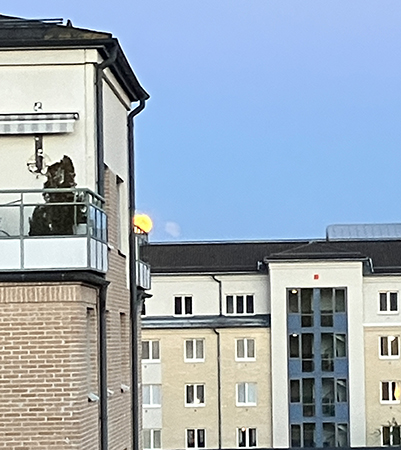 Stor gul måne till höger om det närmaste huset Stor gul måne till höger om det närmaste huset