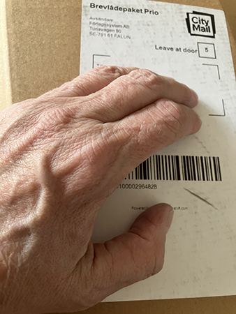 Brunt paket med min hand på