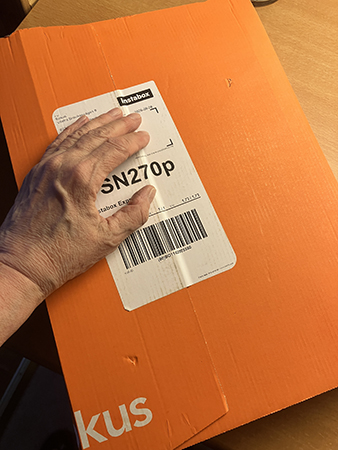 Min hand på ett orange paket