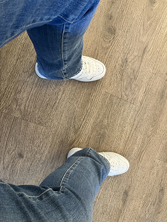 Mina jeansben och fötter i vita gympadojor i väntrummet
