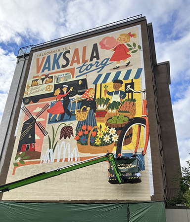 Muralmålning Vaksala torg och två som målar i skylift