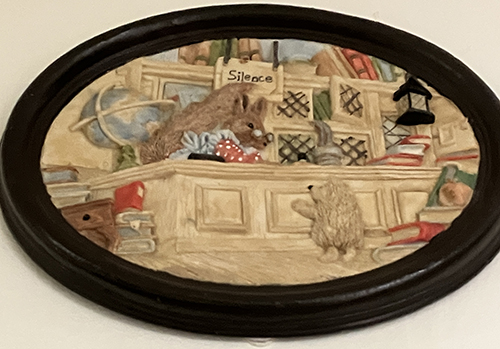 Oval keramiktavla djur i ett bibliotek